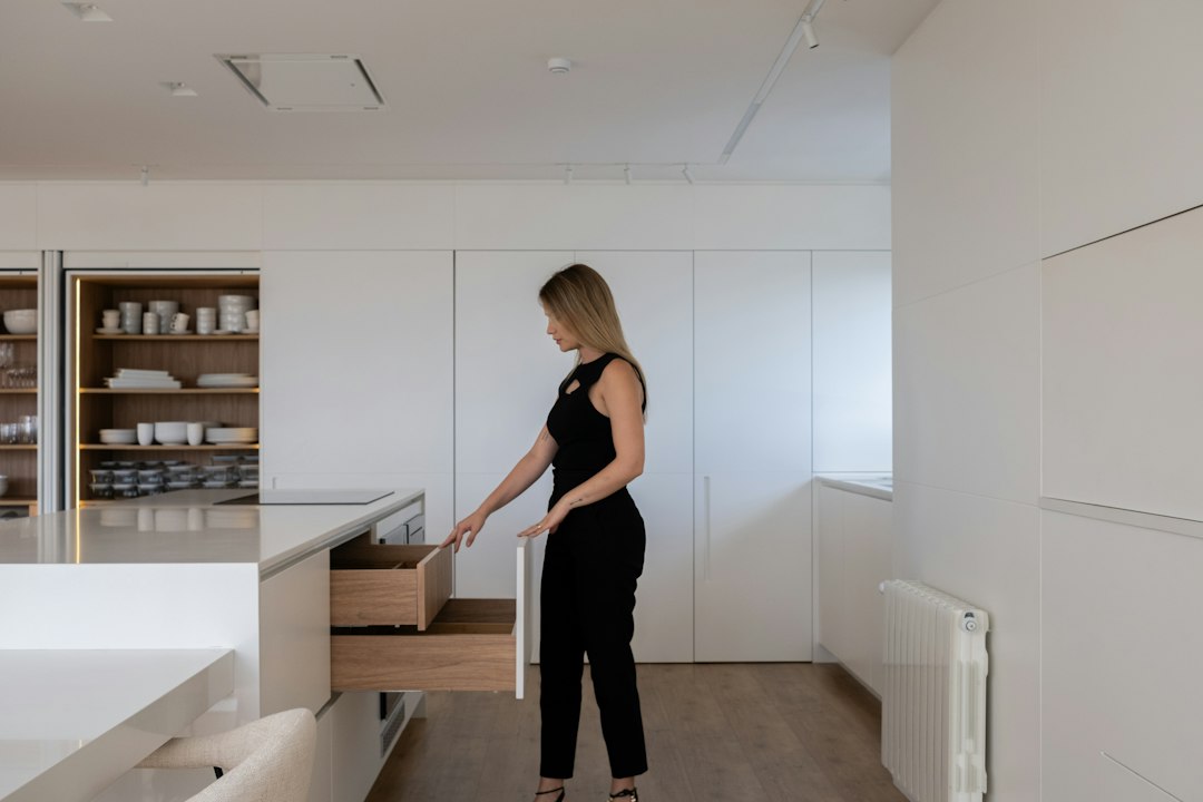 Woman opening kitchen cabinet drawer with organized items inside
